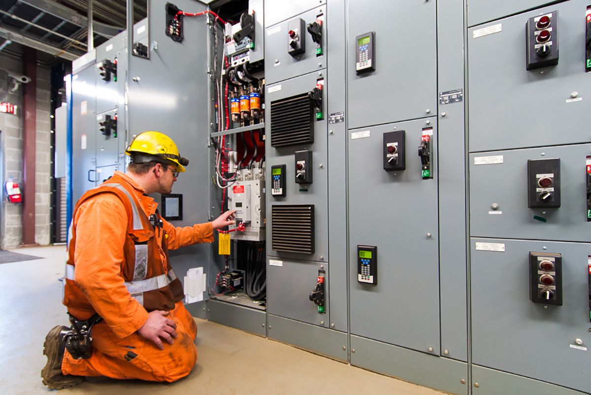 Commercial Electrical Services technician inspecting and maintaining an electrical control panel for safe, reliable, and efficient business power systems.