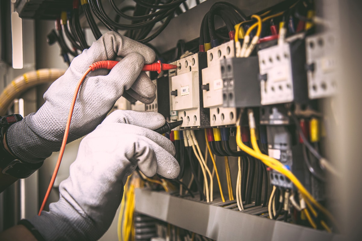 Commercial Electrical Services technician testing and inspecting an electrical control panel to ensure safe, reliable, and efficient commercial power systems.