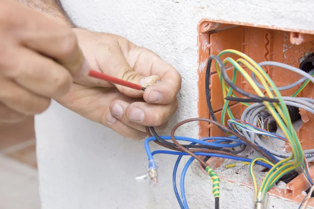 Expert House Rewiring Services with a licensed electrician safely connecting electrical wires for secure, efficient, and code-compliant home wiring.