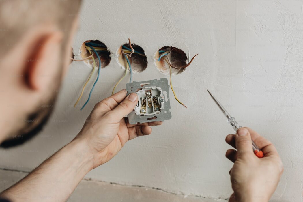 House Rewiring Services by a professional electrician installing electrical outlets for safe, efficient, and code-compliant home wiring.