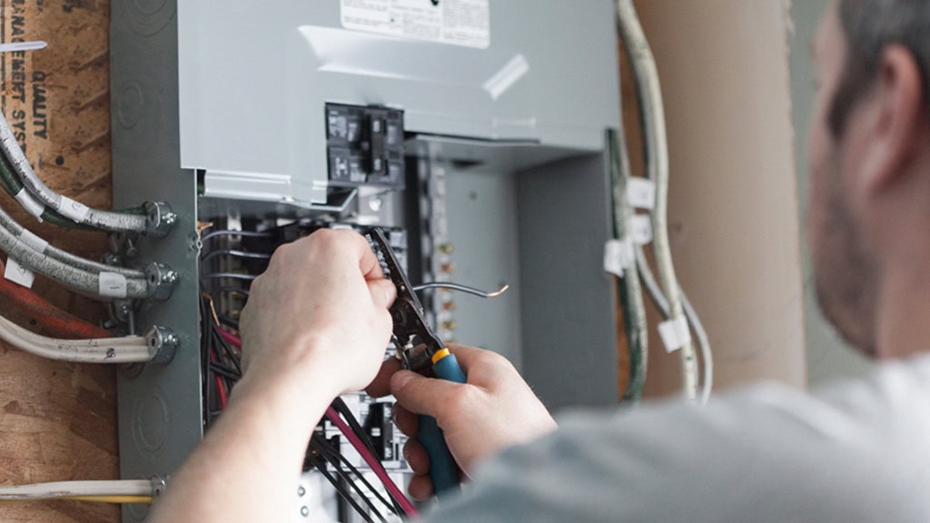 Electrical Panel Upgrade featuring an electrician safely working on a residential electrical panel for improved power and safety.